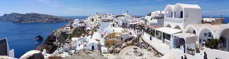 Ia, Santorini / GREECE May 15 2017: Cityscape of Ia, town at Santorini Isle (Greece). people walking along the promenade. View into Caldera of Volcano. made of 6 imagesのeditorial素材