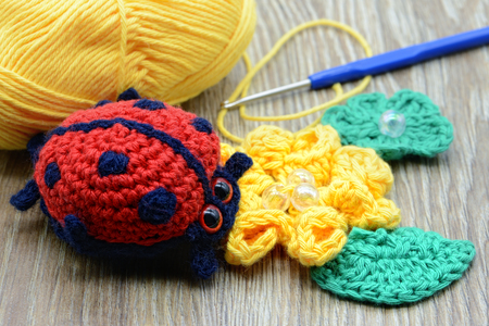 crochet ladybug with flower and wool ball.の写真素材
