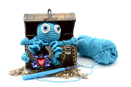 crochet octopus on a jewelry treasure box on white isolated background.の写真素材