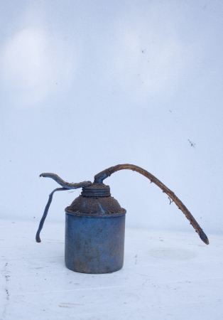 An old greasy blue oil with cobwebs on it on a light backgroundの写真素材