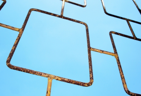 Angled abstract closeup of rusted old gate against blue skylineの写真素材