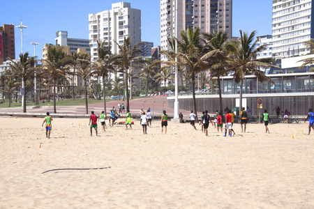 DURBAN, SOUTH AFRICA - FEBRUARY 8, 2014: Group of teenage boys and girls play football on the beach in Durban South Africaのeditorial素材