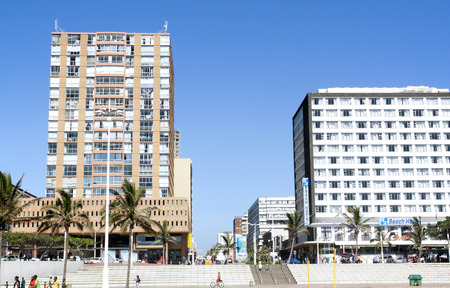 DURBAN, SOUTH AFRICA - FEBRUARY 8, 2014: pedestrians and cyclist on promenade in front of...