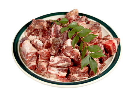 cubes of lamb with sprig of curry leaves ready for cooking