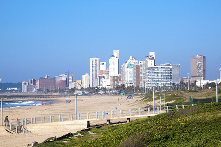 DURBAN, SOUTH AFRICA - MAY 24, 2014: Dune vegetation and many people on beach with Durban city skyline in South Africaのeditorial素材
