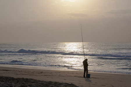 DURBAN, SOUTH AFRICA - JULY 23, 2014: Early morning fisherman fishes on Blue Lagoon beach in Durban, South Africaのeditorial素材