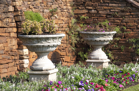 Two concrete urn flower pots in garden botanical garden setting  の写真素材