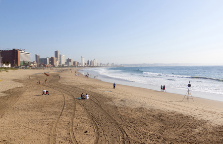 DURBAN, SOUTH AFRICA - JUNE 7, 2015: Many unknown people on beach against city skyline in Durban, South Africaのeditorial素材