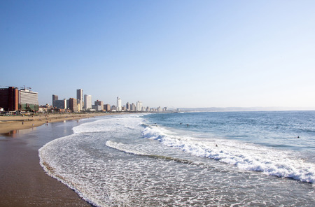 DURBAN, SOUTH AFRICA - JUNE 7, 2015: Many unknown people on Addington beach against city skyline in Durban, South Africaのeditorial素材