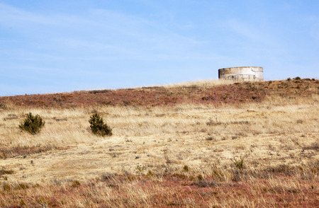 Water reservoir on hill in arid winter grass landscape and blue sky in South Africaの写真素材