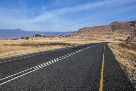 Straight empty asphalt country road road bordered with dry grass in South Africaの写真素材