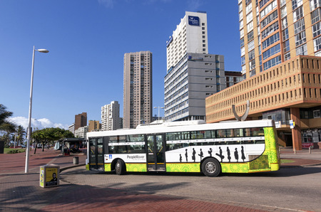 DURBAN, SOUTH AFRICA - MARCH 23, 2016: Municipal bus navigating through roundabout against city...
