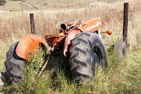 DURBAN, SOUTH AFRICA - MAY 31, 2016 :Vintage abandoned red Massey Ferguson 135 tractor in farm yard  overgrown with grass in Richmond, South Africaのeditorial素材