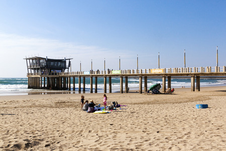 DURBAN, SOUTH AFRICA - JULY 4, 2016: Many unknown people and Vetchs pier against sea and skyline on Addington beachのeditorial素材