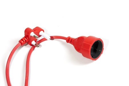 Studio shot close up of red male and female plug and socket of electric extension cable on white backgroundの写真素材