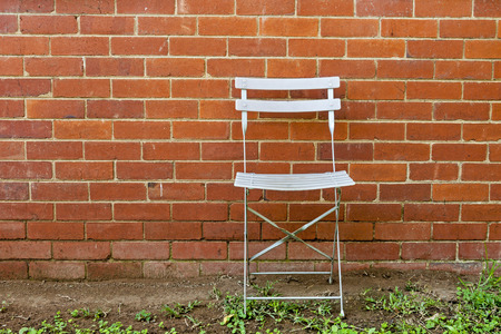Empty outdoor chair against vintage red brick wall patterns and texture backgroundの写真素材