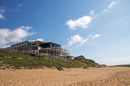 BALLITO, DURBAN, SOUTH AFRICA - DECEMBER 3, 2016: Empty sandy beach against commercial and residential buildings and blue sky at Ballito beach frontのeditorial素材