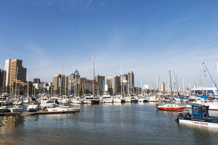 DURBAN, SOUTH AFRICA - DECEMBER 19, 2016: Vessels moored at yacht mole against city skyline in Durban, South Africaのeditorial素材