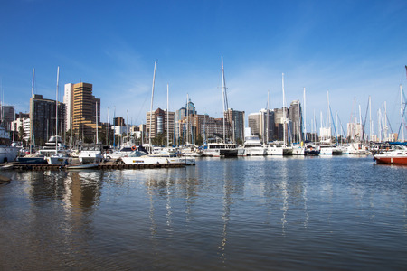 DURBAN, SOUTH AFRICA - DECEMBER 19, 2016: Vessels moored at yacht mole against city skyline in Durban, South Africaのeditorial素材