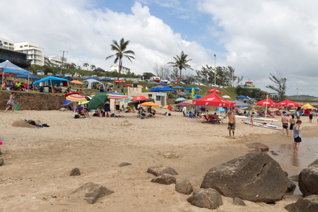 SCOTTBURGH, DURBAN, SOUTH AFRICA - DECEMBER 23, 2016: Many unknown people and colorful umbrellas on early morning  beach at Scottburgh south of Durban in South Africaのeditorial素材