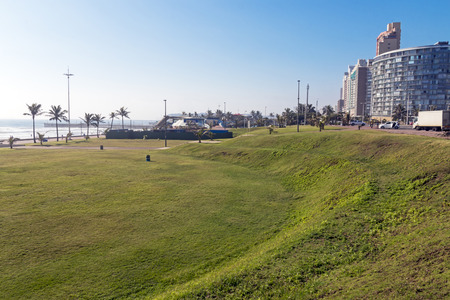 DURBAN, SOUTH AFRICA - JANUARY 24, 2017 : Empty grass verge against city skyline and blue sky on beachfront in Durban, South Africaのeditorial素材