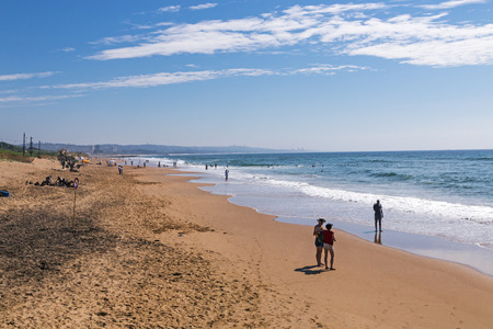 DURBAN, SOUTH AFRICA - MARCH 5, 2017: Many unknown people on morning visit to beach against blue sky and Durban city Skyline in South Africaのeditorial素材