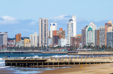 DURBAN, SOUTH AFRICA - APRIL 15 , 2017: Many unknown people on early morning beach against beachfront and city skyline in Durban, South Africaのeditorial素材