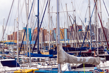 DURBAN, SOUTH AFRICA - APRIL 24, 2017: Early moring close up of yachts moored in harbor against city skyline in Durban, South Africaのeditorial素材