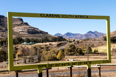CLARENS, ORANGE FREE STATE, SOUTH AFRICA - MAY 17, 2017 : Metal structure framing ashfelt road landscape leading into  of the town of Clarence in South Africaのeditorial素材