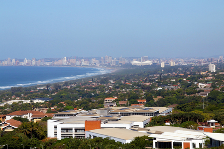 Above view of  commercial and residential buildings urban coastal landscape against blue Durban city skyline in South Africaの写真素材
