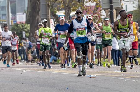 PINETOWN, DURBAN, SOUTH AFRICA - JUNE 10, 2018: Midday many unknownn runners passing through Pinetown whilst competing in the 2018 Comrades marathon between Pietermaritzburg and Durban in South Africaのeditorial素材