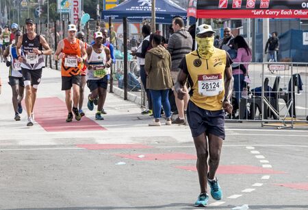 PINETOWN, DURBAN, SOUTH AFRICA - JUNE 10, 2018: Midday many spectators and unknownn runners passing through Pinetown whilst competing in the 2018 Comrades marathon between Pietermaritzburg and Durban in South Africaのeditorial素材