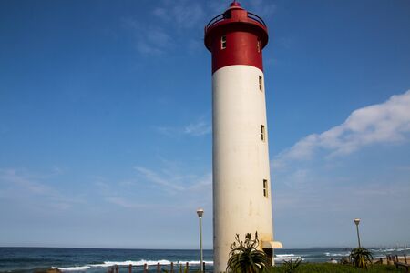 close up of the umhlanga lighthouse with the ocean and the sky in the background