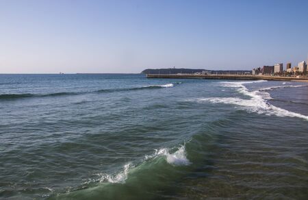 Shallows of Durban beach with pier and bluff in backgroundの写真素材
