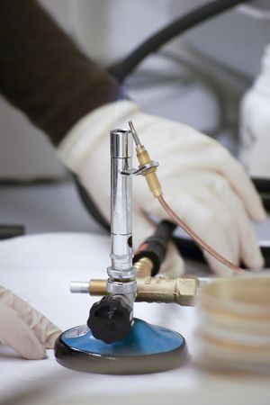 A scientist working with the bunsen burner in the laboratoryの写真素材