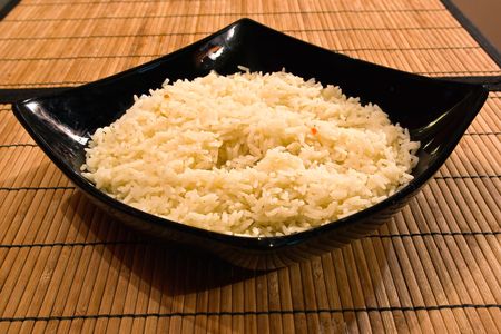 boiled rice in a deep black plateの写真素材