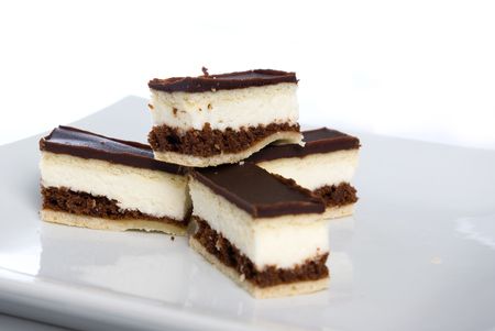 pieces of a chocolate cake with white cream on a plate in shallow depth of fieldの写真素材