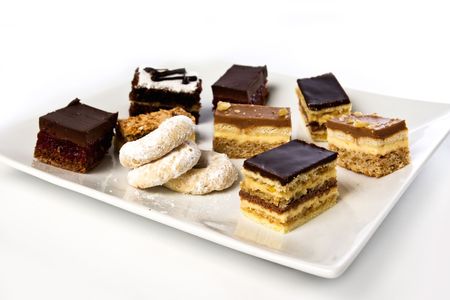 lots of cakes and cookies on a plate isolated on whiteの写真素材