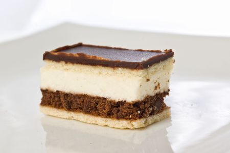 piece of a chocolate cake with white cream on a plateの写真素材