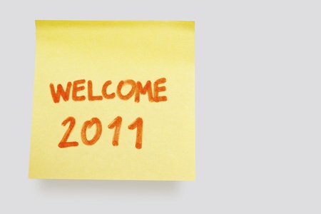 yellow adhesive note on white background with welcome 2011