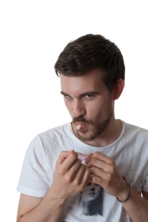 Young attractive bearded man with a candy in his mouth and a devilish lookの写真素材