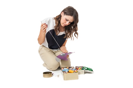 pretty girl sewing fabric on white backgroundの写真素材