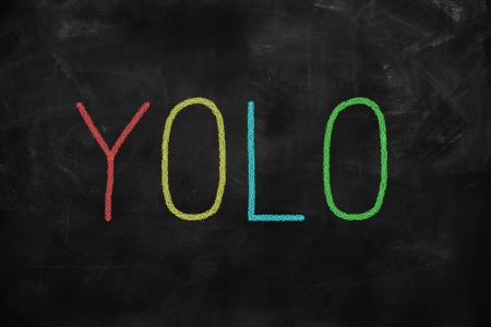 You Only Live Once yolo written on a blackboardの写真素材