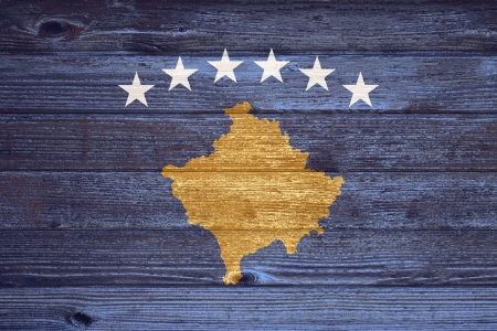 Kosovo Flag painted on old wood plank backgroundの写真素材