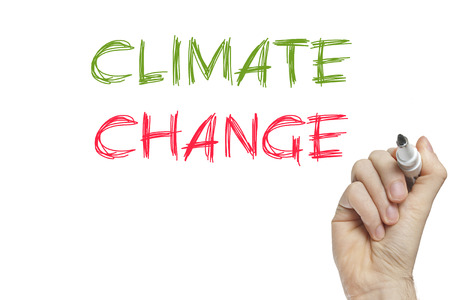 Hand writing climate change on a white boardの写真素材