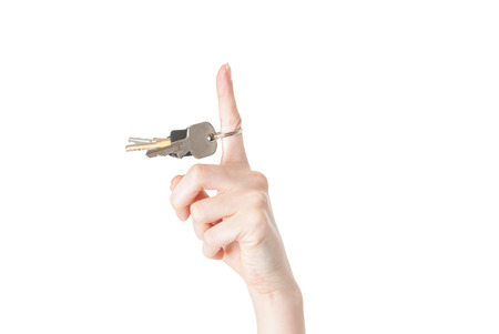 female hand spining a key isolated on white backgroundの写真素材