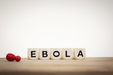 Ebola concept: Dead pawn next to word Ebola spelled by toy diceの写真素材