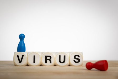 Virus concept: Dead pawn next to word Virus spelled by toy diceの写真素材