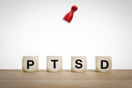 Posttraumatic stress disorder concept: Word PTSD and a falling pawn in motion