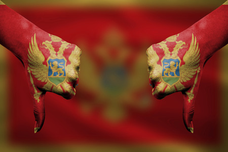 failure of Montenegro - hands gesturing thumbs down in front of flagの写真素材